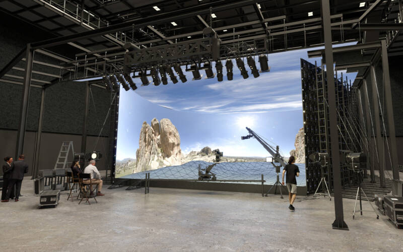 Wide angle shot of a movie studio production set with stage and crew members working