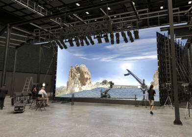 Wide angle shot of a movie studio production set with stage and crew members working